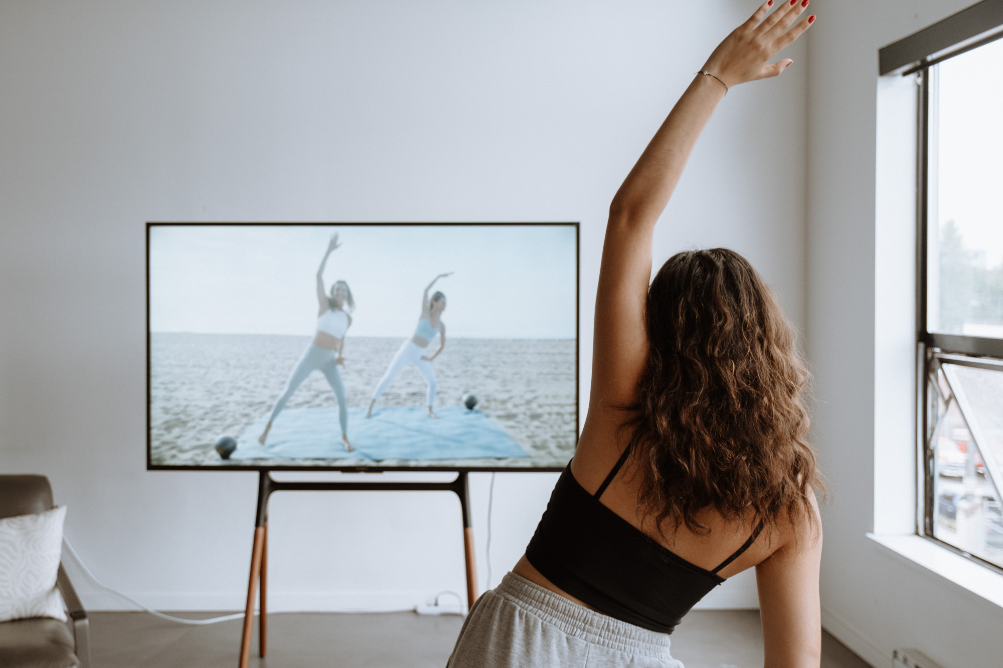 Woman selecting a full-body strength training workout from a streaming fitness platform